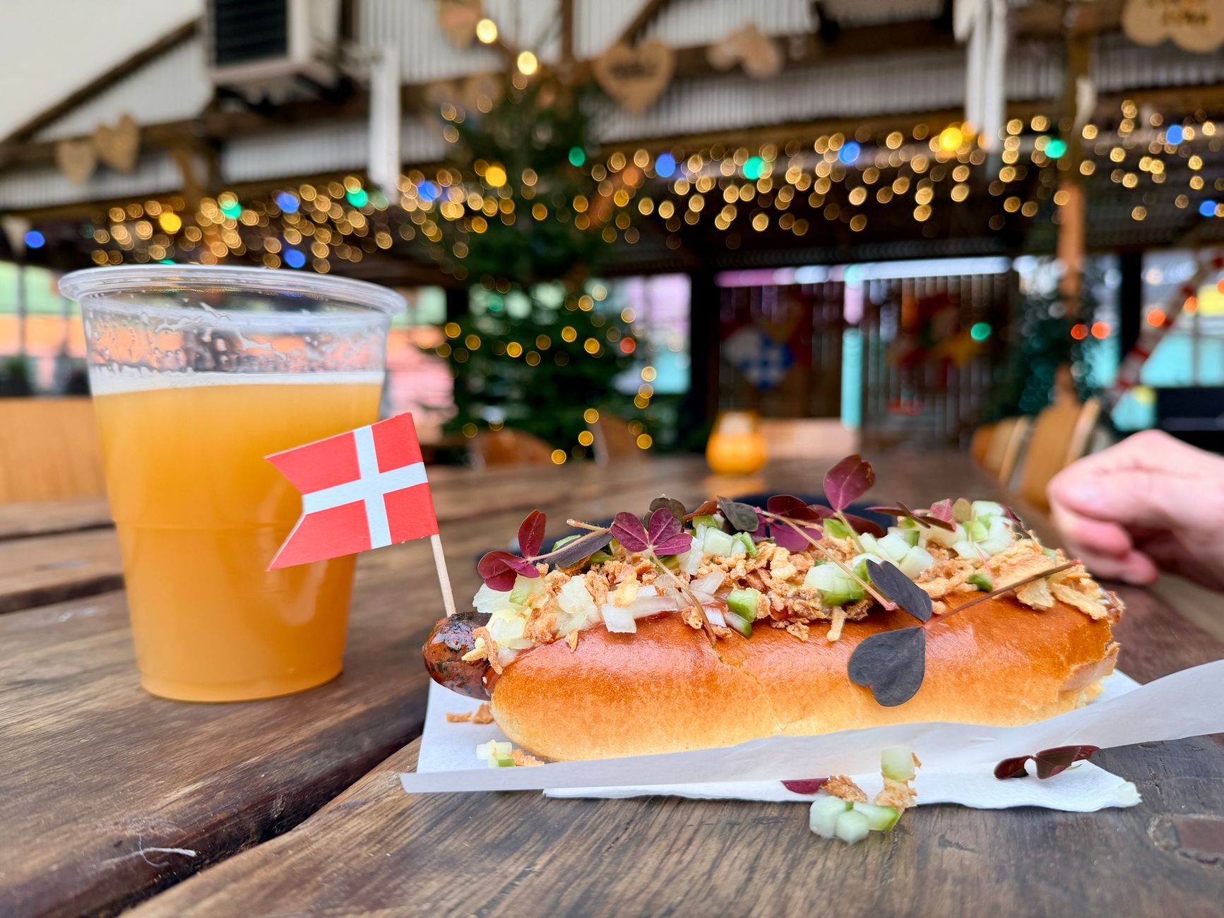 hot dog z czerwoną parówką pod górą cebulki i remolady